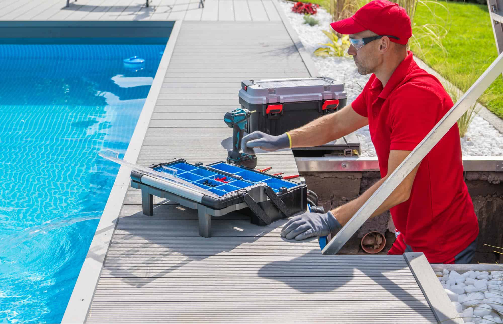 Swimming pool construction contractor in red uniform preparing his tools