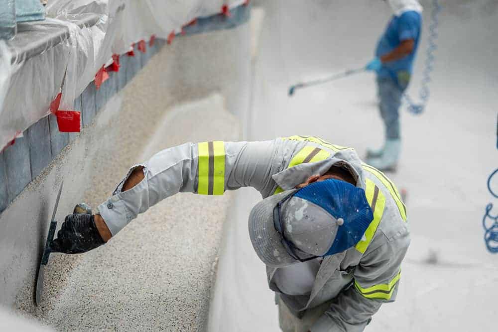 Swimming pool construction contractor resurfacing the pool walls